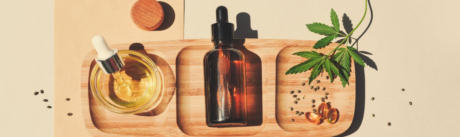 A wooden tray displaying cbd oil and softgels